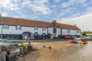 un gran edificio blanco con barcos delante en Water Mill House, en Burnham Market