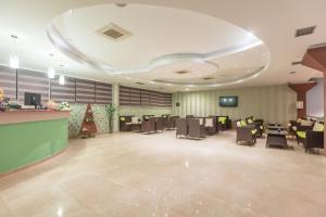 a lobby with a waiting room with tables and chairs at Hotel Sirius Spa & Wellness in Strumica