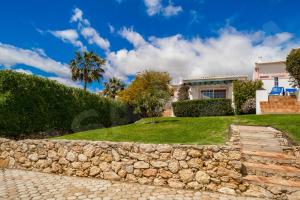a stone wall in front of a house at Quinta do Rosal, Casa Rosa in Carvoeiro