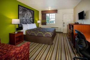 Cette chambre comprend un lit et un bureau. dans l'établissement Super 8 by Wyndham Lake City, à Salt Lake City
