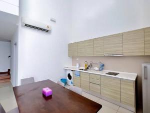 a kitchen with a wooden table and a sink at Duplex 4PX Free Parking @ ICITY, Near SOGO & ThemePark in Shah Alam