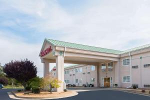 a hotel building with a sign in front of it at Ramada by Wyndham Strasburg - Shenandoah Valley in Strasburg