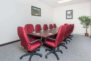 una sala de conferencias con mesa y sillas rojas en Ramada by Wyndham Strasburg - Shenandoah Valley, en Strasburg