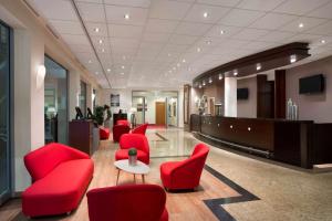 a lobby with red chairs and a waiting room at Ramada Encore by Wyndham Geneva in Geneva