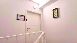 un corridoio con una porta bianca e un orologio sul muro di Design-Apartmenthaus für bis zu 12, modern, Dachterrasse, Grill, ruhige Lage, Disney plus, Wii, LAN und WLAN a Norimberga