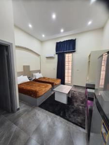 Un dormitorio con dos camas y una mesa dentro. en زافيرو محطه الرمل للعائلات فقط - families only, en Alejandría