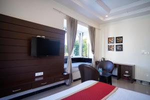 a bedroom with a bed and a tv on a wall at Tiger's Trail Hotel & Food Court in Kumbhalgarh