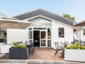 a patio with tables and chairs and an umbrella at ibis Compiegne in Compiègne