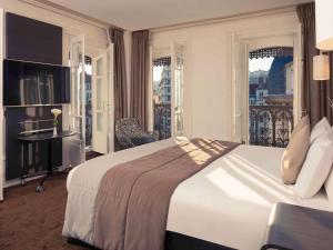 a hotel room with a large bed and a balcony at Mercure Lyon Centre Beaux-Arts in Lyon