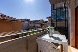 una mesa en un balcón con un jarrón de flores en Appartamento Alba Rosa 3 - MyHo Casa, en Alba Adriatica