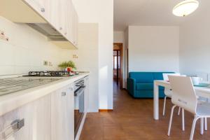 cocina y sala de estar con sofá azul en Appartamento Alba Rosa 3 - MyHo Casa, en Alba Adriatica