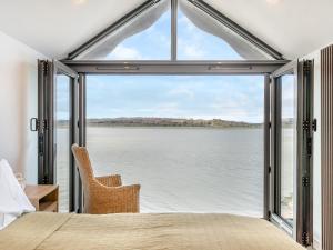 a bedroom with a view of the water at Beach Haven in Arnside