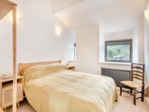 sypialnia z łóżkiem, krzesłem i oknem w obiekcie Beach Haven w mieście Arnside