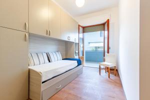 1 dormitorio con 1 cama, 1 mesa y 1 silla en Appartamento Alba Rosa 3 - MyHo Casa, en Alba Adriatica