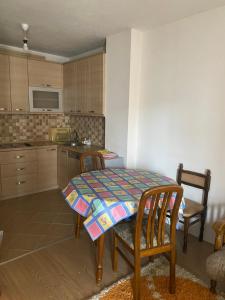 a kitchen with a table and two chairs and a table and a kitchen at Kosova in Kosovo Polje