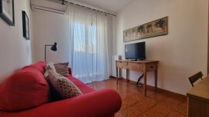 sala de estar con sofá rojo y TV en BeBelle Casa Vacanze, en Polignano a Mare