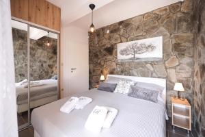 ein Schlafzimmer mit einem großen Bett und einer Steinmauer in der Unterkunft Villa Rita I in Nin