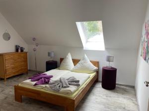 a bedroom with a bed with a purple bow on it at Urlaub am Plätlinsee - Haus Elisa in Wustrow