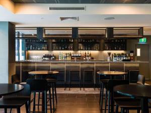 a bar in a restaurant with tables and chairs at Ibis Christchurch in Christchurch