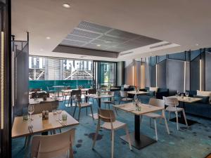 - un restaurant avec des tables et des chaises dans une salle dans l'établissement Ibis Christchurch, à Christchurch