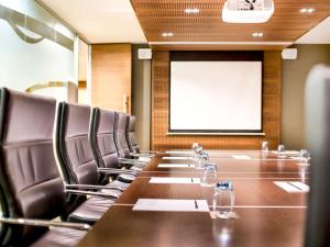 a conference room with a long table and leather chairs at Novotel Christchurch Cathedral Square in Christchurch