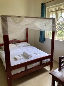 a bedroom with a bunk bed with a canopy at Bwindi Guest House in Kinkizi
