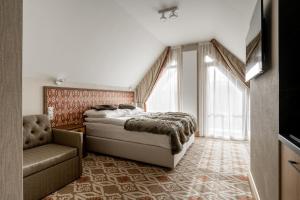 a bedroom with a bed and a chair at Aries Residence Bukowina in Bukowina Tatrzańska