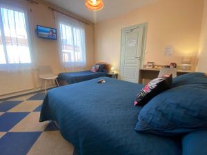 een slaapkamer met een blauw bed en een stoel bij Hotel le Pasteur in Royan