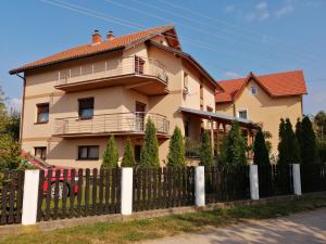 una casa con una valla delante de ella en Apartmani Tvins en Soko Banja