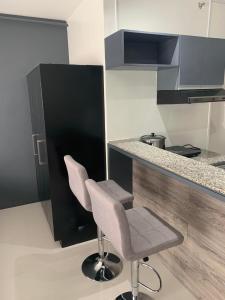 a kitchen with two chairs next to a counter at Condo Bacolod City in Bacolod