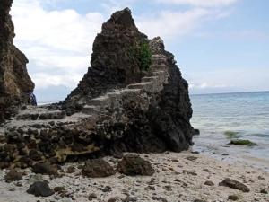 una pared de piedra en una playa cerca del océano en Jeremiah Homestay near Masasa Beach, en Batangas