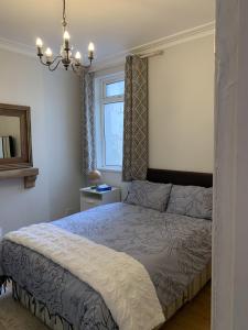 1 dormitorio con cama y ventana en Adanhouse-stockland spacious 5 bedroom house sleeps 12 private garden, en Cardiff