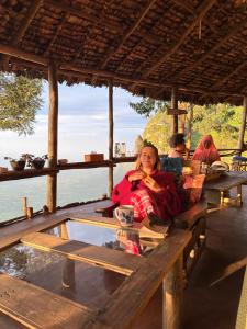 a woman sitting at a table in front of the water at Uvi House & Restaurant 