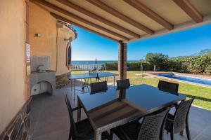a patio with a table and chairs and a swimming pool at LXR Villa frente al Mar 3HAB in Mijas