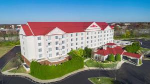 a large white building with a red roof at Hilton Garden Inn Louisville-Northeast in Louisville