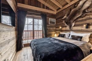 sypialnia z łóżkiem w chacie z bali w obiekcie Chalet 3 étoiles pour 4 pers avec vue imprenable sur la vallée de Chamonix w mieście Les Houches