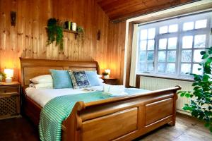 una camera con letto in legno e finestra di 3 Bed Cabin in the Woods a Barham