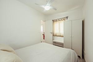 a white bedroom with a bed and a cabinet at Algés Village Casa 4 by Lisbon-Coast vacation in Algés