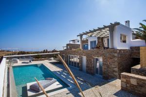a villa with a swimming pool and a house at Myconian Platinum Villas in Kalafatis