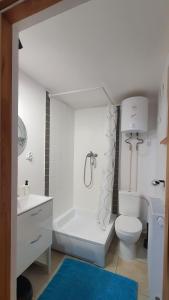 a white bathroom with a toilet and a sink at Domek na kolonii Brąswałdu in Dywity