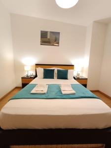 a bedroom with a large bed with two towels on it at Invicta Porto Guest House in Porto