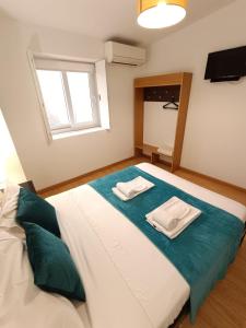 a bedroom with a large bed with two towels on it at Invicta Porto Guest House in Porto