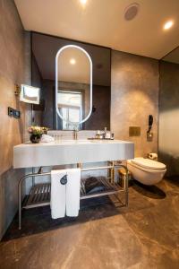 a bathroom with a sink and a toilet and a mirror at Radisson Collection Hotel, Vadistanbul in Istanbul