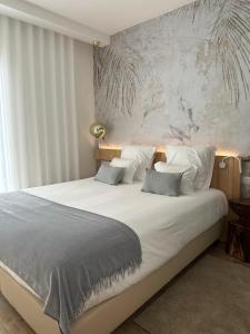 1 dormitorio con 1 cama grande con sábanas y almohadas blancas en Charm-In Center en Vila Nova de Milfontes