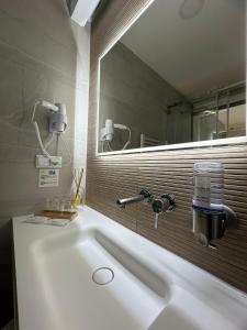 a bathroom with a white sink and a mirror at Charm-In Center in Vila Nova de Milfontes