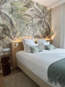 a bedroom with a large white bed with a mural at Charm-In Center in Vila Nova de Milfontes