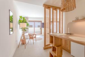 a kitchen with white walls and a table and chairs at Reina Victoria Velázquez in Alicante