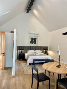 1 dormitorio con 1 cama, mesa y sillas en Mountain Cottages at Haskell Vineyard en Stellenbosch