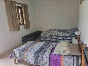 a bedroom with two beds and a window at Recanto Videira Rota do Vinho in São Roque