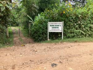 una señal frente a un arbusto con una valla en Bwindi Guest House, en Kinkizi